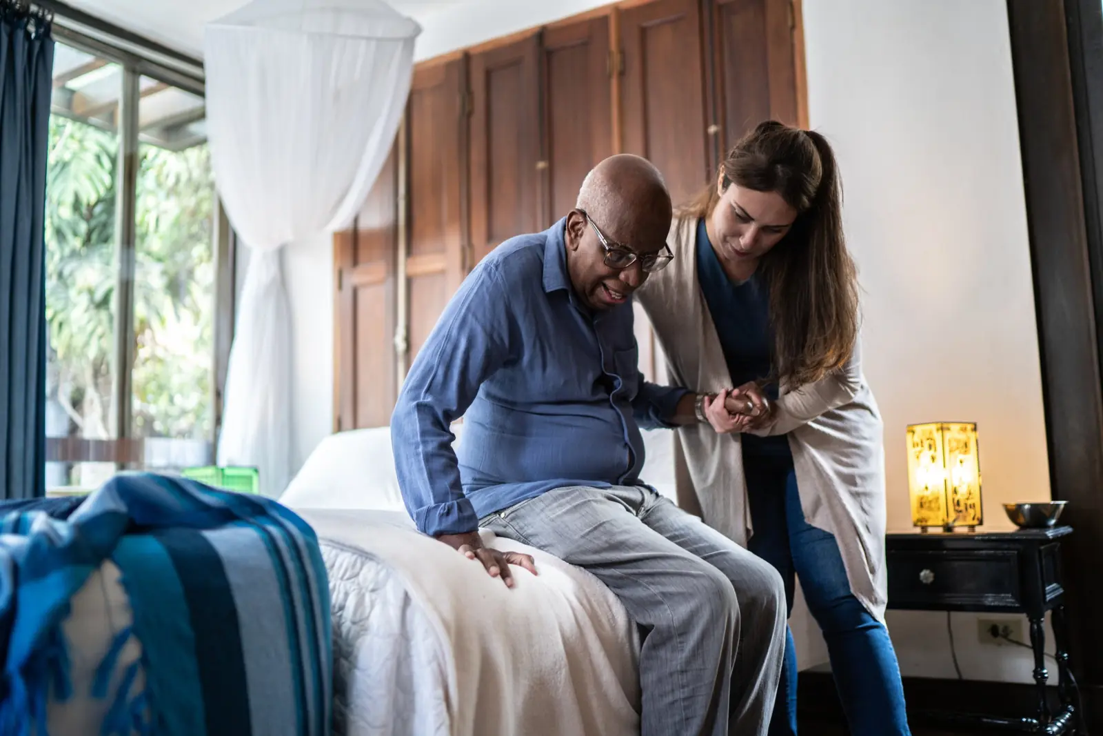 Caregiver helping a senior man after a hospital discharge