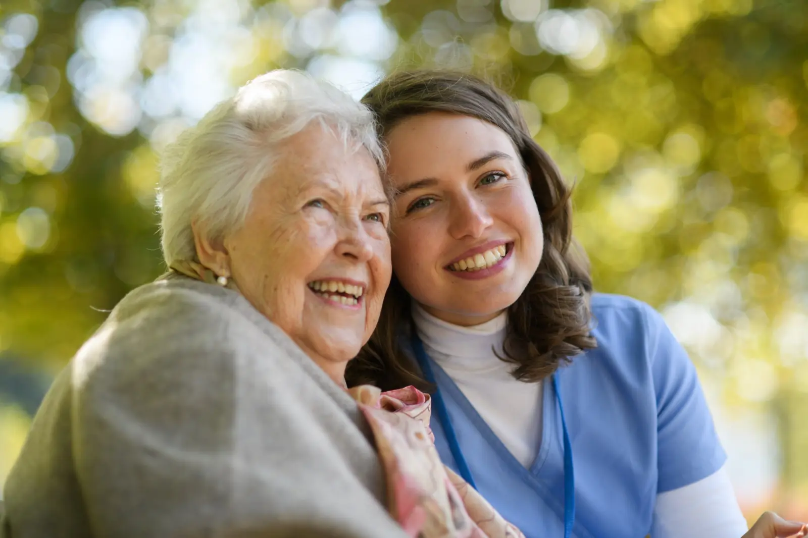 Nurse and senior woman smiling together outdoors