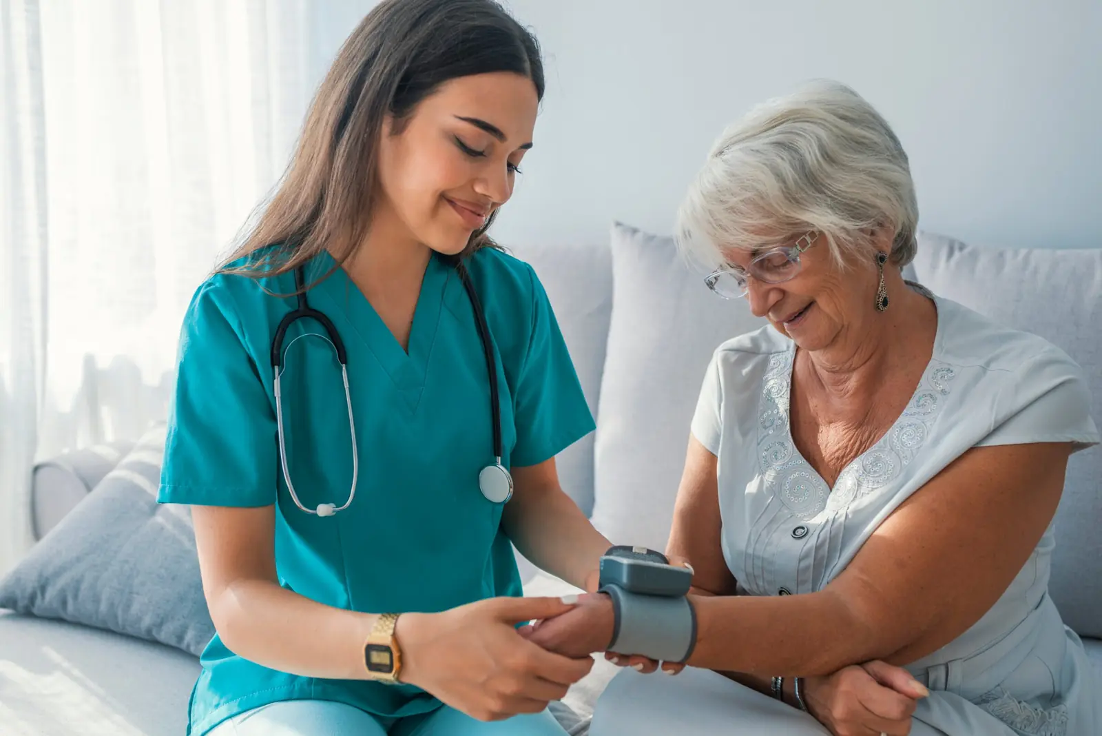 Home health nurse checking a senior woman's blood pressure