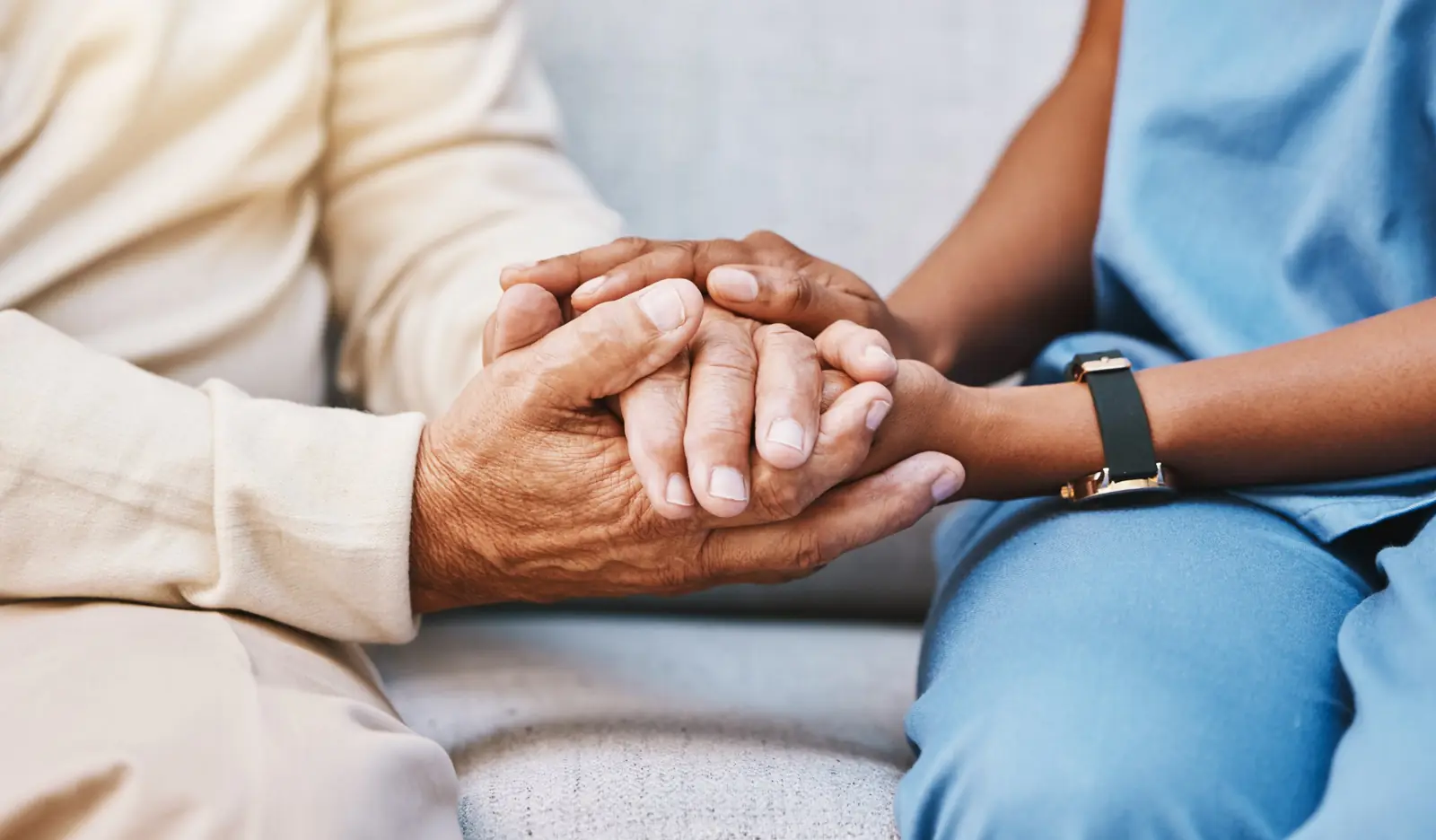 Nurse holding a patient's hands during a home wound care visit