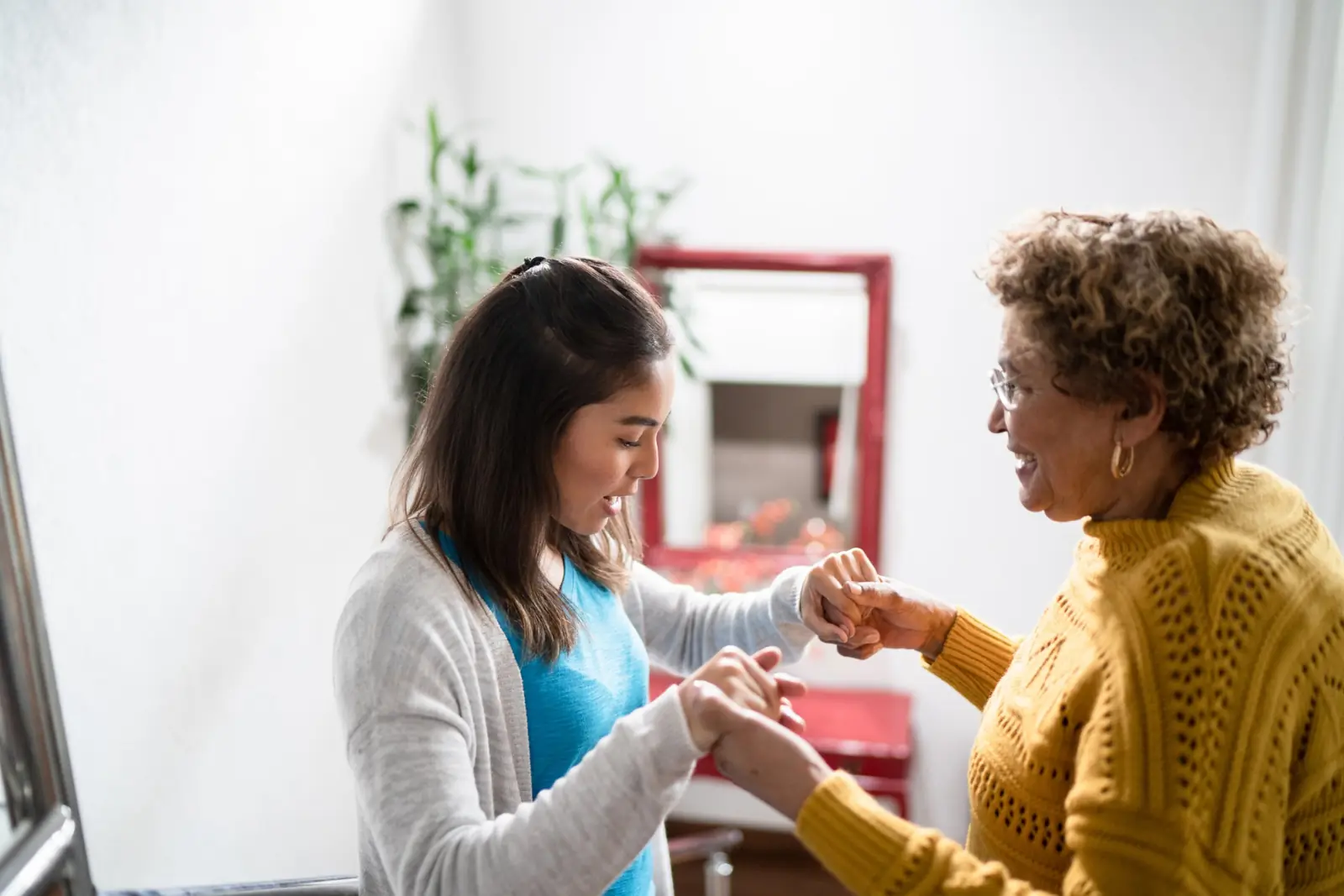 Therapist helping a senior woman with movement at home