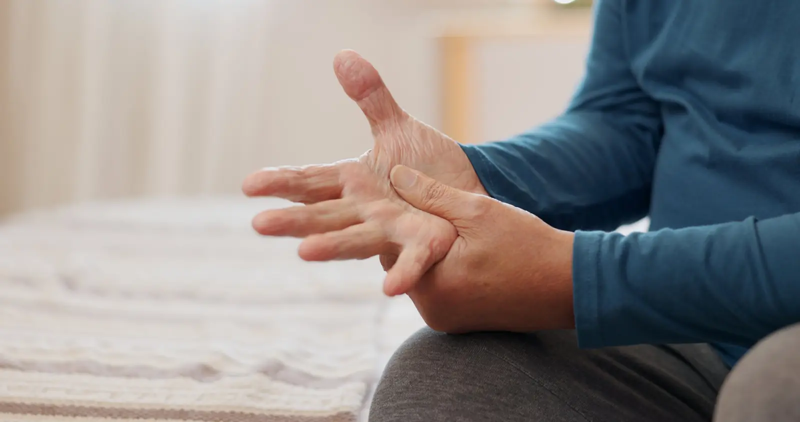 Senior rubbing a sore hand during a pain assessment