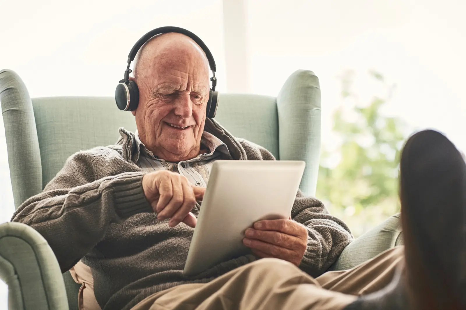 Senior man reviewing information on a tablet at home